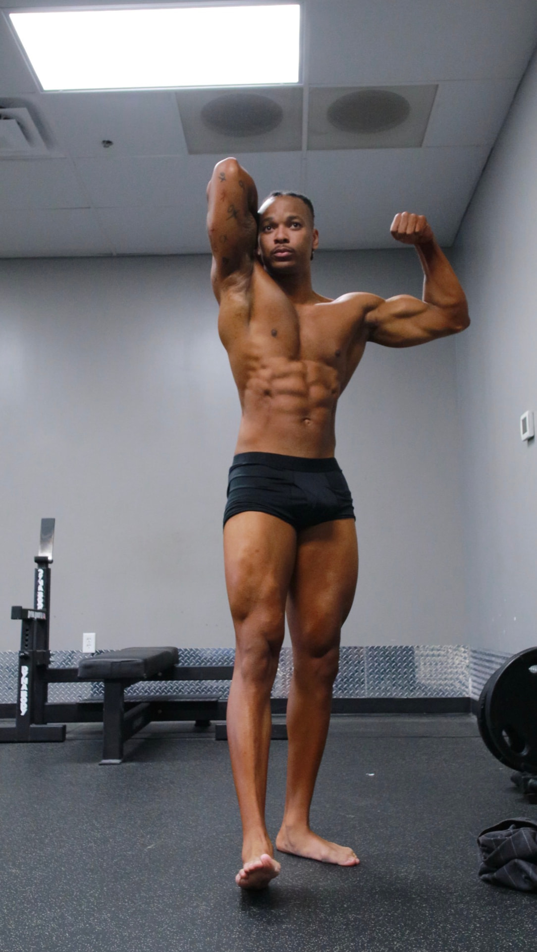 Male bodybuilder hitting an abdominal pose with full conditioning in the gym